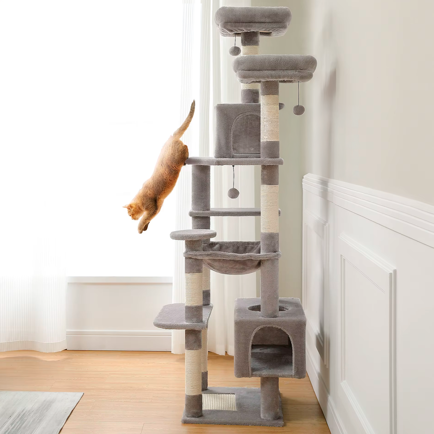 Cat climbing a multi-level cat tree in a room with light wood flooring and white walls.